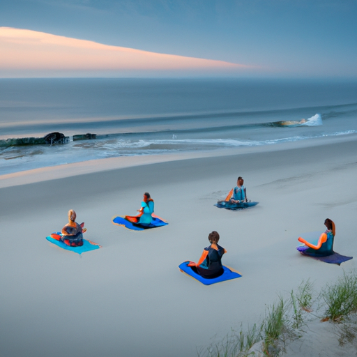 A group of people doing yoga on a beach at sunrise.